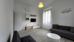 uma sala de estar com um sofá e uma televisão em Green Central house em La Spezia