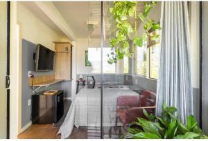 1 dormitorio con 1 cama y TV en una habitación en Guest room Casa SEA en Florianópolis