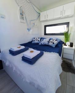 een slaapkamer met een bed met handdoeken erop bij ARKA 2 - Houseboat w centrum Mielna, rower wodny, parking, Wi-Fi in Mielno