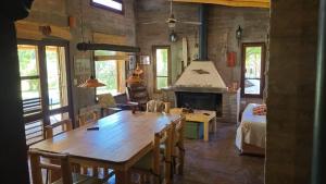 a living room with a wooden table and a fireplace at La Loica in Barreal