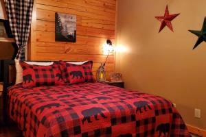 a bedroom with a red and black checkered bed at Enchanted Star Cabin in Ranger