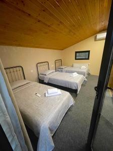 a group of three beds in a room at Qoqosa In Racha in Ambrolauri