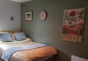 - une chambre avec un lit et une horloge murale dans l'établissement Affordable Flats - Derby City Centre, à Derby