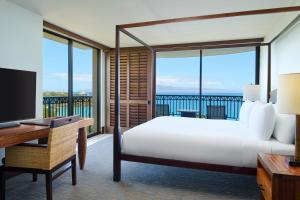 a bedroom with a bed and a desk with a tv at Royal Lahaina Resort & Bungalows in Lahaina