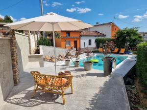 un patio con una silla y una sombrilla junto a la piscina en Casa Luana, en Roč