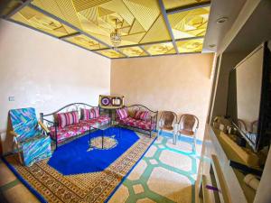 een woonkamer met een bank en een tafel en stoelen bij استمتع بالإقامة في فيلا أحلامك in El Khemis des Meskala