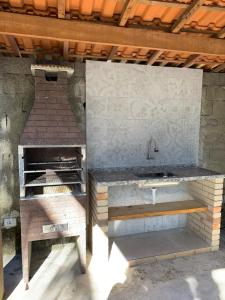 uma cozinha exterior com um lavatório e um fogão em Casa Litoral Sul de São Paulo, Peruibe em Itariri
