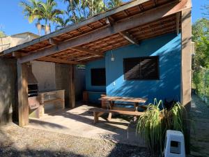 Casa azul con pérgola de madera y mesa de picnic en Casa Litoral Sul de São Paulo, Peruibe en Itariri