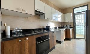 a kitchen with white cabinets and a black stove top oven at Cosy Bay appartement 4 - 5px in Agadir