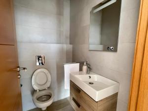 a bathroom with a toilet and a sink and a mirror at Cosy Bay appartement 4 - 5px in Agadir +18 photos