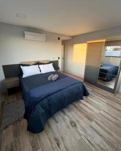 um quarto com uma cama grande e um espelho grande em Apartamento La Vie em São Joaquim
