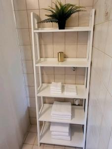 un estante de toallas blancas en el baño con toallas en Ferienwohnung am Bodensee, en Tettnang
