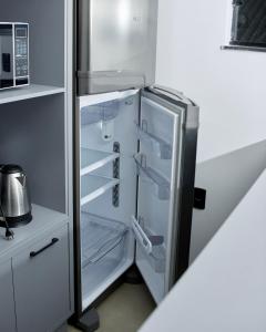 an empty refrigerator with its door open in a kitchen at Apartamento La Vie in São Joaquim
