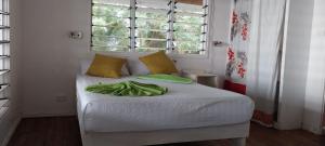 a bedroom with a bed with white sheets and a window at Maravu Taveuni Lodge in Matei