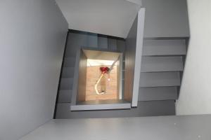 a stairwell with a window with a bouquet of flowers at Corte LOIOL in Scorzarolo