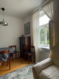 een woonkamer met een bank, een tafel en een raam bij Apartment VilaPark 14 in Rogaška Slatina