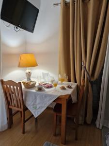 a small table with a lamp and a table with two chairs at Recanto da Serra - Alojamento Local in Lousã