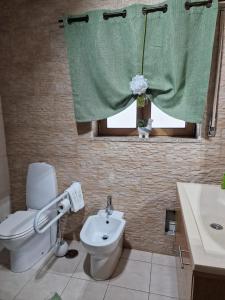 a bathroom with a toilet and a sink and a window at Recanto da Serra - Alojamento Local in Lousã