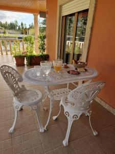 Recanto da Serra - Alojamento Local في لوسا: طاولة بيضاء وكراسي على الفناء