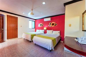 1 dormitorio con 2 camas y pared roja en Hotel Gran Centenario, en Mérida