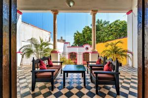 um pátio com cadeiras, uma mesa e uma casa em Hotel Gran Centenario em Mérida