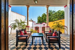 a patio with chairs and a table and a house at Hotel Gran Centenario in Mérida