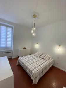a white bedroom with a bed and a window at Grands T2 Cours Napoleon in Ajaccio