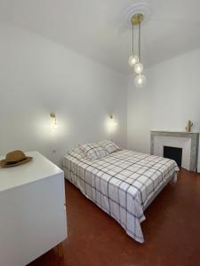 a white bedroom with a bed and a fireplace at Grands T2 Cours Napoleon in Ajaccio