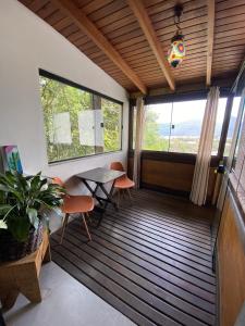 uma varanda com uma mesa e cadeiras e uma janela em Guest room Casa SEA em Florianópolis