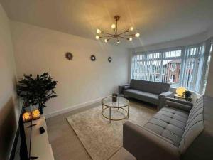 uma sala de estar com um sofá e uma mesa em Lovely 3-Bed House near Birmingham Airport & Nec em Solihull