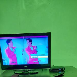 una pantalla de televisión con dos hombres jugando un videojuego en Banrai Kunchay Wangnamkhiao en Ban Huai Nam Khem