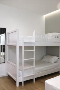 a white bunk bed in a white room at David's Studio Stays in Vlorë
