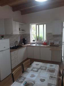 a kitchen with white cabinets and a table and a window at B&B Sophie in Naples