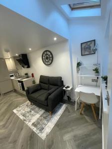 a living room with a couch and a clock on the wall at Stylish & Cosy 1 Bed Apartment in Swindon