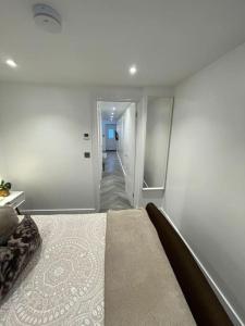 a white room with a bed and a hallway at Stylish & Cosy 1 Bed Apartment in Swindon