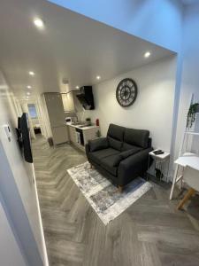 uma sala de estar com um sofá e um relógio na parede em Stylish & Cosy 1 Bed Apartment em Swindon