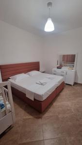um quarto com uma cama grande e um candeeiro em Vivienne's Apartment em Saranda