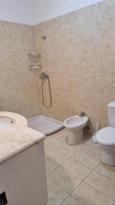 uma casa de banho com um chuveiro, um WC e um lavatório. em Vivienne's Apartment em Saranda