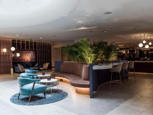 eine Lobby mit einem Sofa, Tischen und einer Bar in der Unterkunft Radisson Blu Royal Viking Hotel, Stockholm in Stockholm