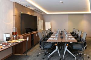 a conference room with a long table and chairs at Clarion Hotel Jeddah Airport in Jeddah