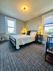 ein Schlafzimmer mit einem großen Bett und zwei Fenstern in der Unterkunft Gifford House in Provincetown