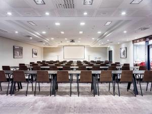 a conference room with tables and chairs and a whiteboard at Radisson Blu Royal Viking Hotel, Stockholm in Stockholm
