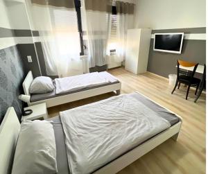 Zimmer mit 2 Betten und einem TV. in der Unterkunft 4RENT Apartments in Worms