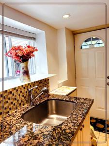 a kitchen with a sink and a vase of flowers at toronto midtown spacious room in Toronto
