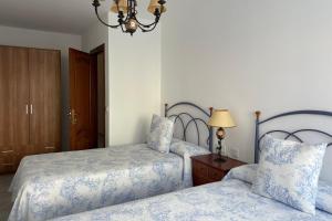 een slaapkamer met 2 bedden en een kroonluchter bij SanMar in Finisterre