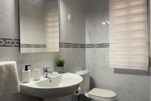 Baño blanco con lavabo y aseo en SanMar, en Finisterre