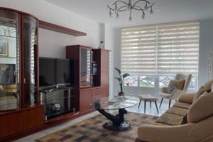 uma sala de estar com um sofá e uma televisão em SanMar em Finisterre