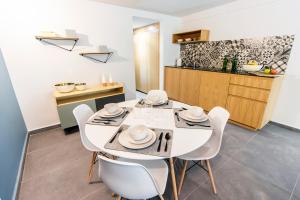 a dining room with a white table and chairs at NIU Modern & Centric Lofts in Mexico City