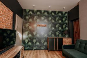 salon ze ścianą z malowidłem roślinnym w obiekcie Apartament Mazury Kętrzyn „Kopernik” w mieście Kętrzyn