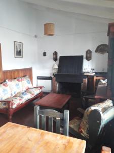 a living room with a couch and a piano at Casa Rosales in San Martín de los Andes